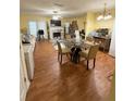 Open floor plan features wood floors, fireplace, white mantel, TV, dining table, and desk at 6550 Wellington Chase Ct, Lithonia, GA 30058