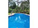 Sparkling blue in-ground pool surrounded by lush landscaping, perfect for relaxation and summer fun at 938 Lost Valley Drive Southeast Se Dr, Conyers, GA 30094
