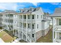 View of three story home featuring double balconies, white trim and brick accents on the ground level at 1294 Six Sisters St, Dacula, GA 30019
