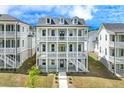 View of three story home featuring double balconies and a well manicured lawn at 1294 Six Sisters St, Dacula, GA 30019