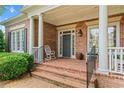 Inviting front porch with brick flooring, rocking chair, and ample space for relaxing at 2117 Stephens Walk, Dunwoody, GA 30338