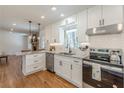 Modern kitchen featuring white cabinetry, granite countertops, stainless steel appliances, and hardwood flooring at 442 Mountain Park Trl, Stone Mountain, GA 30087