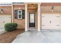 Front entrance with a black front door, white trim and a one car garage at 2735 Sudbury Trce, Norcross, GA 30071