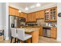 Open concept kitchen with wood cabinets, stainless steel appliances, and island with granite countertop at 11 Perimeter E Ctr # 1412, Atlanta, GA 30346