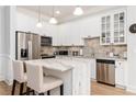 Bright kitchen features white cabinets, stainless appliances, island with marble countertop, and pendant lighting at 11 Perimeter E Ctr # 1412, Atlanta, GA 30346