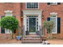 Inviting front entrance with brick steps, decorative columns, and elegant lighting fixtures at 1870 Milfield Cir, Snellville, GA 30078