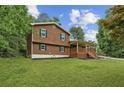 Side view of a cozy two-story house showcasing a green lawn and mature trees in the background at 860 The Cir, Lawrenceville, GA 30043