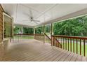 Spacious outdoor deck with brown railings and a white ceiling fan overlooking lush greenery at 860 The Cir, Lawrenceville, GA 30043