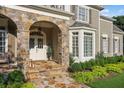 Inviting front porch with stone pillars, decorative lighting, and well-maintained landscaping at 443 Langley Oaks Dr, Marietta, GA 30067