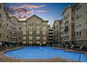 Exterior view of a community pool surrounded by lounge chairs and apartment buildings at 800 Peachtree Ne St # 8607, Atlanta, GA 30308