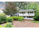 Charming two-story home featuring landscaped front yard, complemented by trees for added shade at 1329 W Nancy Creek Ne Dr, Brookhaven, GA 30319