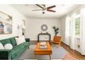 Bright living room featuring a green sofa, wooden furniture, and a striped rug at 2041 Trailwood Rd, Decatur, GA 30032