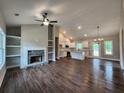 Bright living room with fireplace and built-in shelves open to kitchen with island at 92 Jeffrey Ln, Dallas, GA 30157
