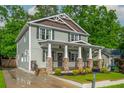 Charming two-story home featuring a welcoming front porch with stone pillars, set on a well-manicured lawn at 176 Olympic Pl, Decatur, GA 30030