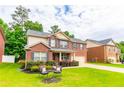 Inviting two-story brick home with green lawn and chairs on a beautiful day at 12275 Styron Dr, Hampton, GA 30228