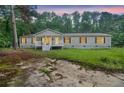 View of the front of the house at twilight, showcasing the yard and the front porch at 4060 Highway 81, Hampton, GA 30228