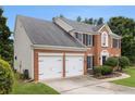 Traditional brick home with a two-car garage, manicured lawn, and mature landscaping at 505 Stedford Lane, Duluth, GA 30097
