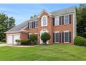 Traditional brick home with a two-car garage, manicured lawn, and mature landscaping at 505 Stedford Lane, Duluth, GA 30097