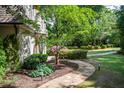 A backyard showcasing a stone path winding through manicured landscaping and lush greenery at 5140 Long Island Nw Dr, Sandy Springs, GA 30327