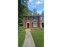Charming brick home featuring dark green shutters and lush lawn at 932 Chippendale Ln, Norcross, GA 30093