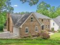 Beautiful brick home with attached garage and lush landscaping at 10300 Carleigh Ln, Roswell, GA 30076