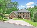 Charming home with a well-maintained front yard and a long driveway nestled in a wooded neighborhood at 10300 Carleigh Ln, Roswell, GA 30076