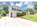 Split-level home with an attached garage, driveway, and well-manicured lawn at 2767 Kathie Ln, Ellenwood, GA 30294