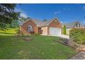 Beautiful brick home with a well-manicured lawn and a two-car garage at 3946 Village Crossing Ln, Ellenwood, GA 30294