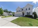 View of a lovely gray two-story home with a well-manicured lawn, and a two-car garage on a sunny day at 522 Evans Ln, Woodstock, GA 30188