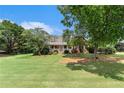 Traditional brick home with a large front yard featuring mature trees offering shade and curb appeal at 1112 Sutton Dr, Mcdonough, GA 30252