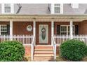 Inviting front porch with brick pillars, a white picket fence, and a decorative wreath on the front door at 1112 Sutton Dr, Mcdonough, GA 30252