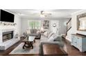 Cozy living room with a brick fireplace, neutral-toned sofas, and hardwood floors creating a comfortable space at 1112 Sutton Dr, Mcdonough, GA 30252