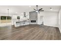 Bright, open living room and kitchen area features hardwood floors, stone fireplace, and modern appliances at 3233 Glynn Mill Dr, Snellville, GA 30039