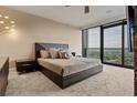 Serene bedroom with a large window showcasing a green view, plush carpet, and a contemporary style platform bed at 3344 Peachtree Ne Rd # 3405, Atlanta, GA 30326