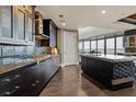 Modern kitchen featuring dark cabinetry, stainless steel appliances, and an island with stone countertop and unique tile accents at 3344 Peachtree Ne Rd # 3405, Atlanta, GA 30326