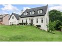 Charming home featuring a well-manicured lawn, black roof, white facade, and an attached garage at 1645 Oakfield Ln, Roswell, GA 30075