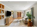 Bright living room with hardwood floors, neutral walls, and French doors to sun room at 1652 Oak Grove Rd, Decatur, GA 30033
