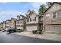 Street view of well-maintained townhomes with two-car garages, neutral siding, and tidy landscaping at 2294 Spicy Pine Ln, Lawrenceville, GA 30044