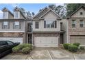 Inviting townhome featuring stone accents, neutral siding, a two-car garage, and tidy landscaping at 2294 Spicy Pine Ln, Lawrenceville, GA 30044