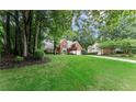 A beautiful exterior view of a brick home with a lush green lawn and mature trees in a serene neighborhood at 1340 Gran Forest Dr, Cumming, GA 30041