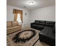 Cozy living room featuring a black sectional sofa and a patterned area rug at 45 Avery Drive, Covington, GA 30016