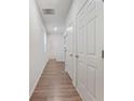 Bright hallway featuring wood flooring and neutral walls with white doors at 826 Bentley Dr, Fairburn, GA 30213