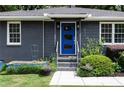 Home featuring a vibrant blue front door, modern exterior lighting, and well-maintained landscaping at 957 Sharon Se Cir, Smyrna, GA 30080