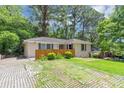 Well-kept ranch-style home with a fenced yard, rock driveway, and lush trees at 2702 Rollingwood Se Ln, Atlanta, GA 30316