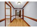 Inviting hallway with hardwood floors, wood trim, and neutral paint, seamlessly connecting rooms at 362 Clyde Ct, Mcdonough, GA 30252
