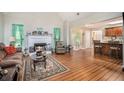Open-concept living room with hardwood floors, brick fireplace and is adjacent to the kitchen at 1907 S Van Wert Rd, Villa Rica, GA 30180