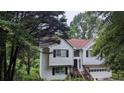 Charming two-story home with an attached garage surrounded by mature trees at 5710 Cardigan Trce, Sugar Hill, GA 30518