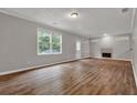 Spacious living room with light gray walls, wood floors, a fireplace, and a large window at 1707 Taylor Ave, Atlanta, GA 30344