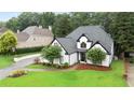 White house with dark trim surrounded by lush greenery, a well-kept lawn, and a winding driveway at 2714 Twin Leaf Trl, Marietta, GA 30062
