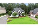Beautiful white home featuring lush green lawn, mature trees, and a welcoming driveway at 2714 Twin Leaf Trl, Marietta, GA 30062